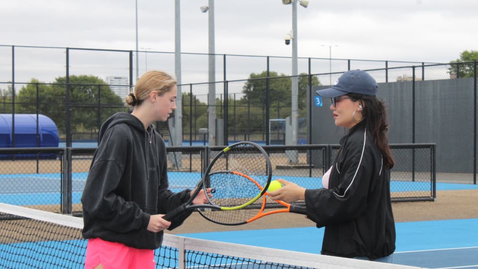 Two students playing tennis