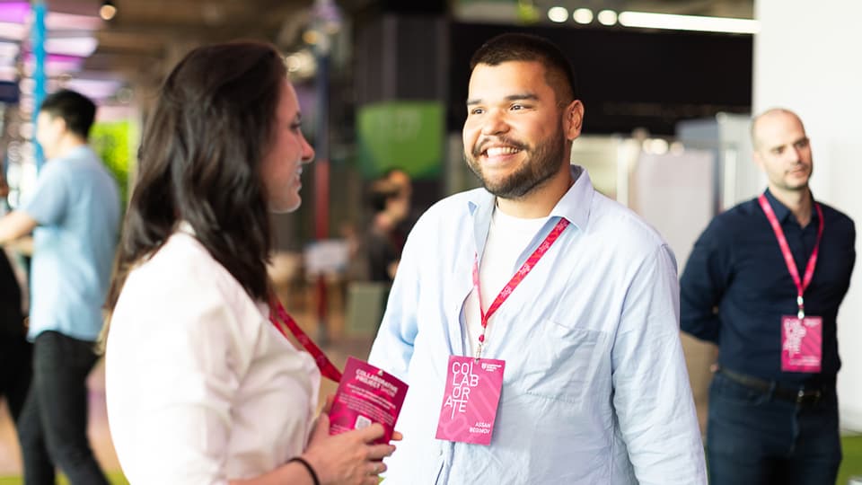 A student smiling and having a conversation with another student