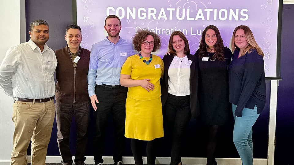a group of people standing in front of a projected image