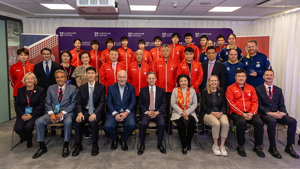 Team China and Chinese embassy diplomats sat taking a group picture