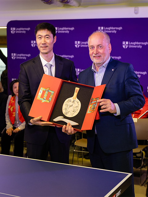 Nick Jennings and Chinese embassy diplomat holding a signed ping pong racket