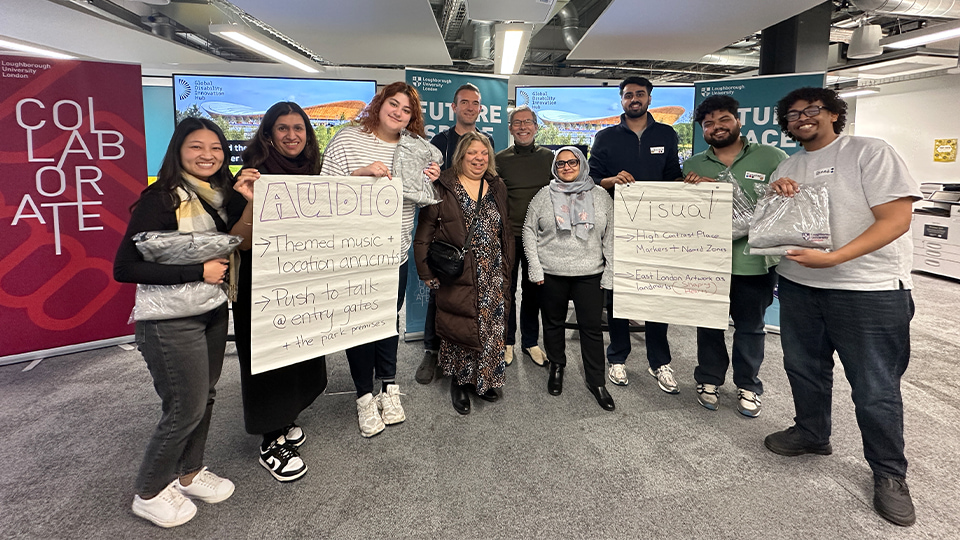 Loughborough University London students photographed holding up presentation notes