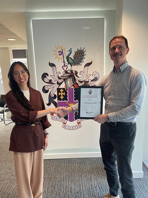 Student and Dean of Loughborough University London holding up scholarship certificate