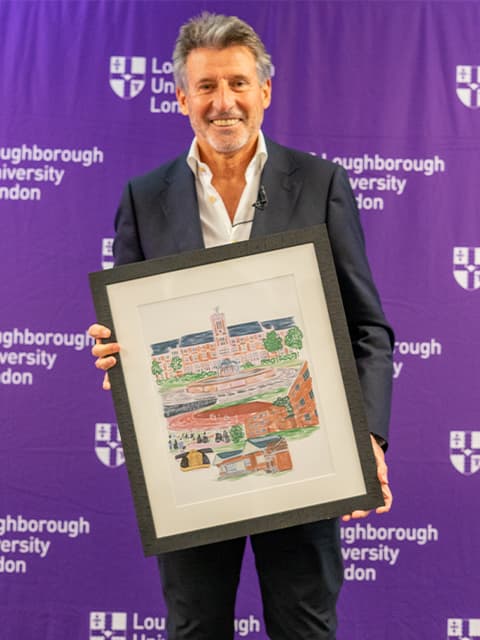 Lord Sebastian Coe photographed with a commissioned picture of Loughborough University