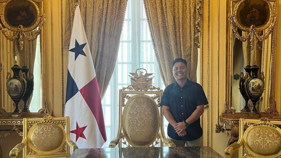 Mario Fernández pictured standing next to the Panama flag inside a room.