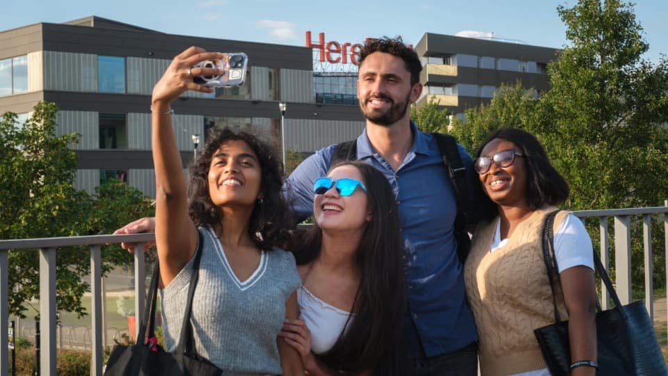 Four students taking a selfie outside